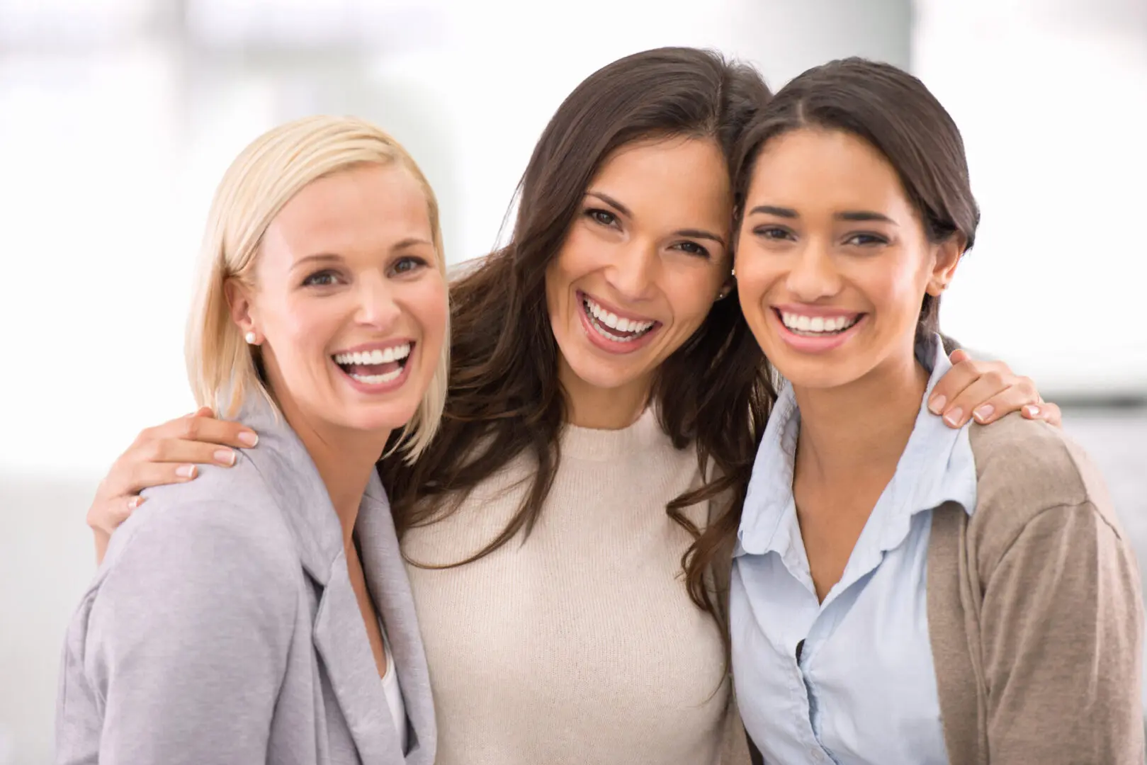 Three women smiling for a picture together.